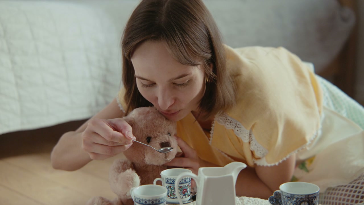 Young Woman Playing Tea Party with Teddy Bear