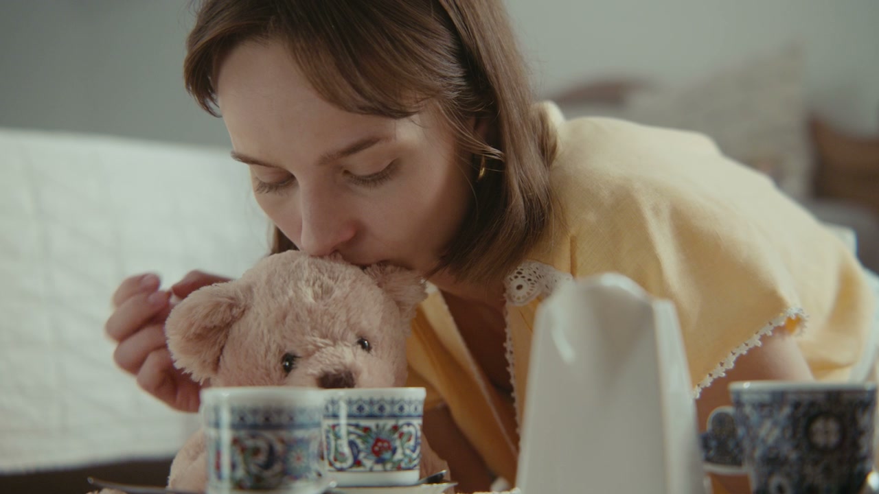 Woman Kissing Teddy Bear at Tea Party