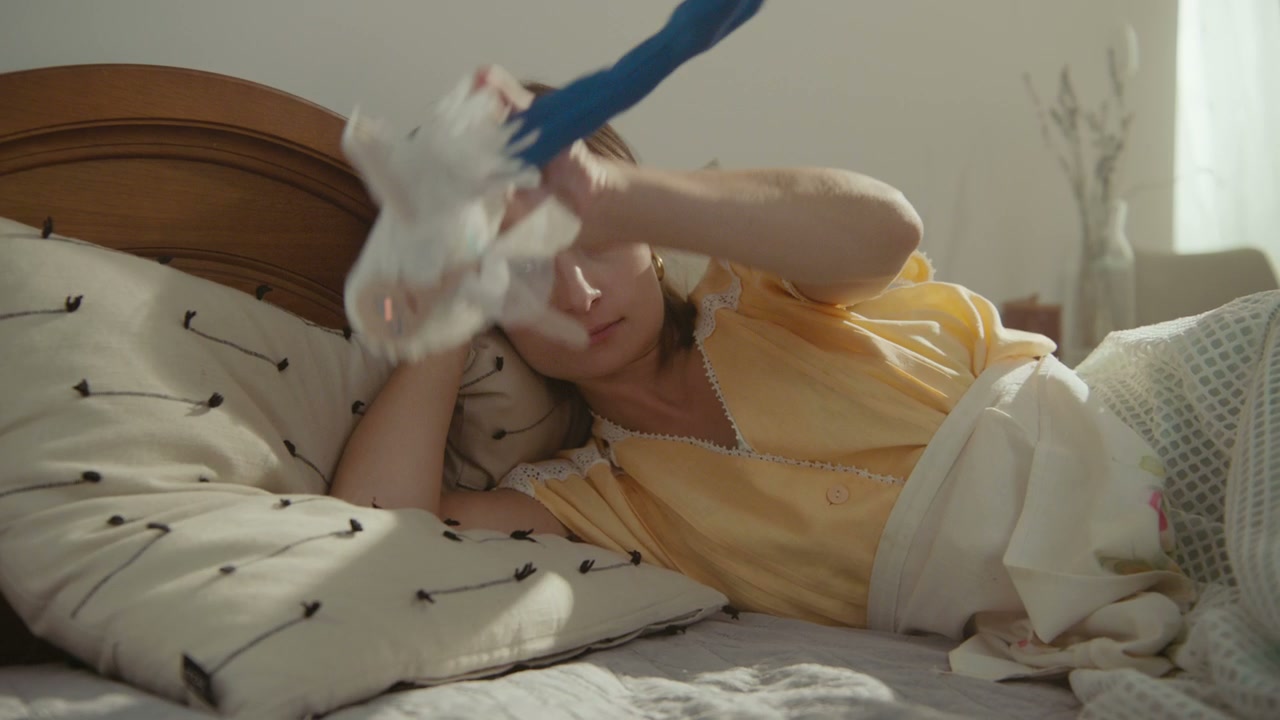 Woman Playing with Doll in Bed