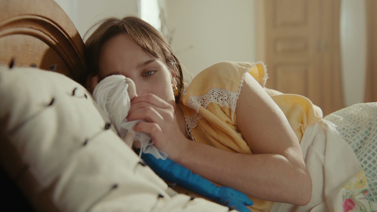Young Woman Lying in Bed Playing with Doll