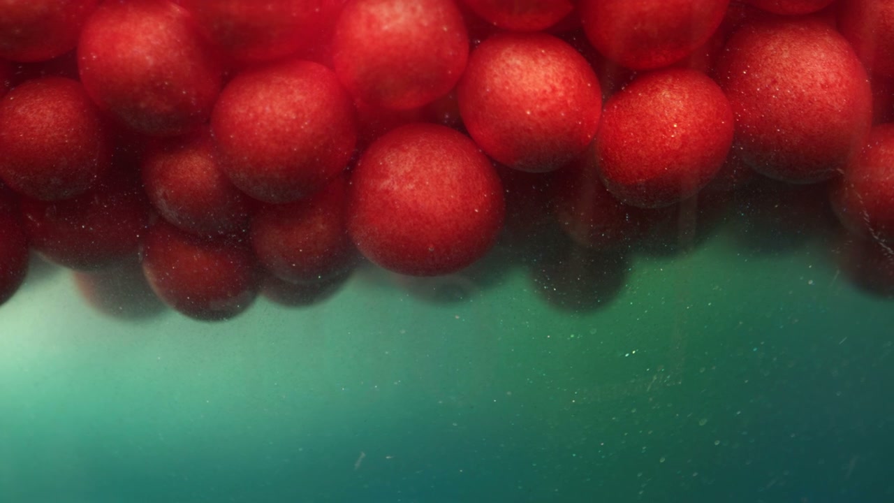 Red Spheres Floating in Abstract Green Liquid