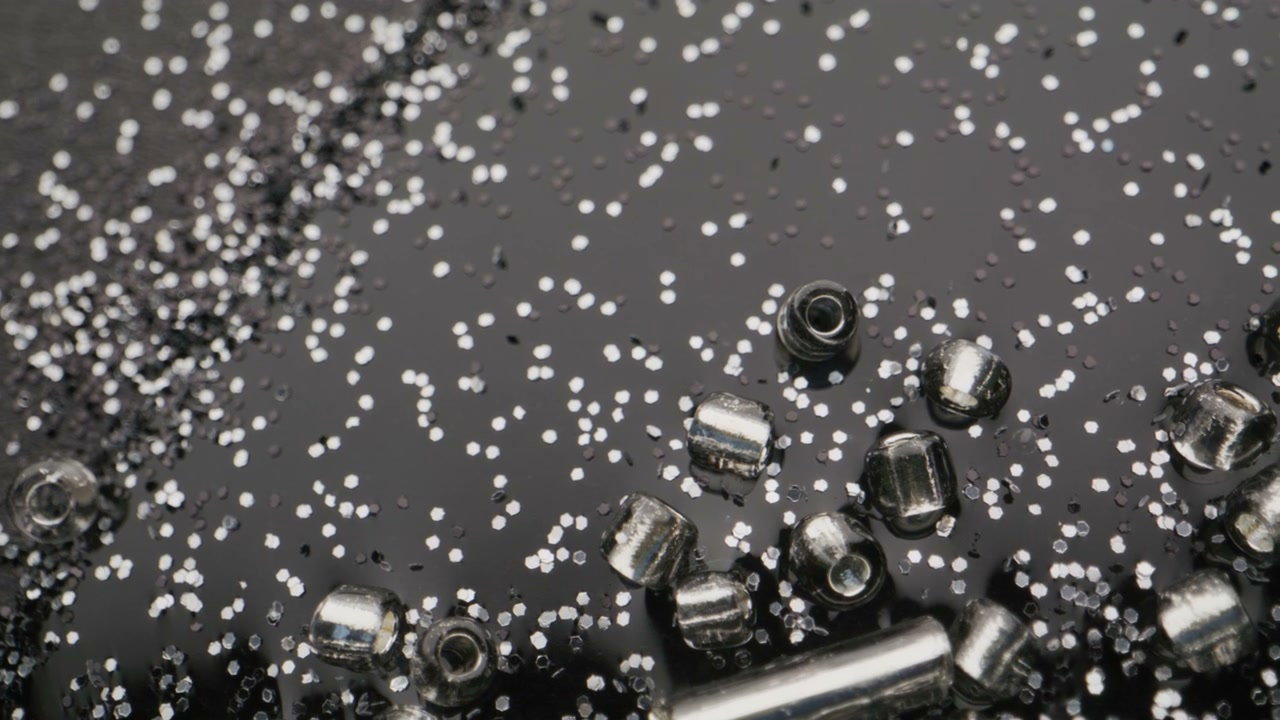 Metallic Beads and Glitter on a Black Surface