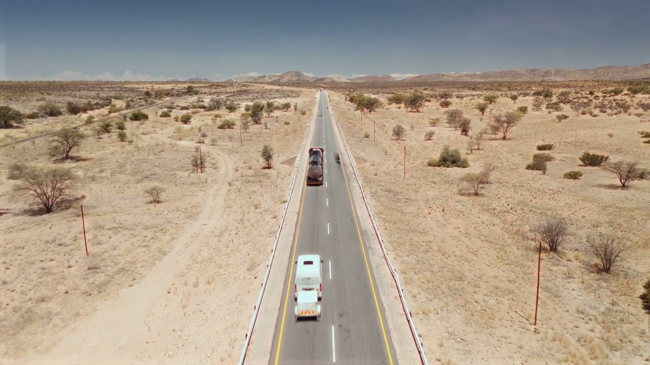 Long Desert Road with Passing Vehicles