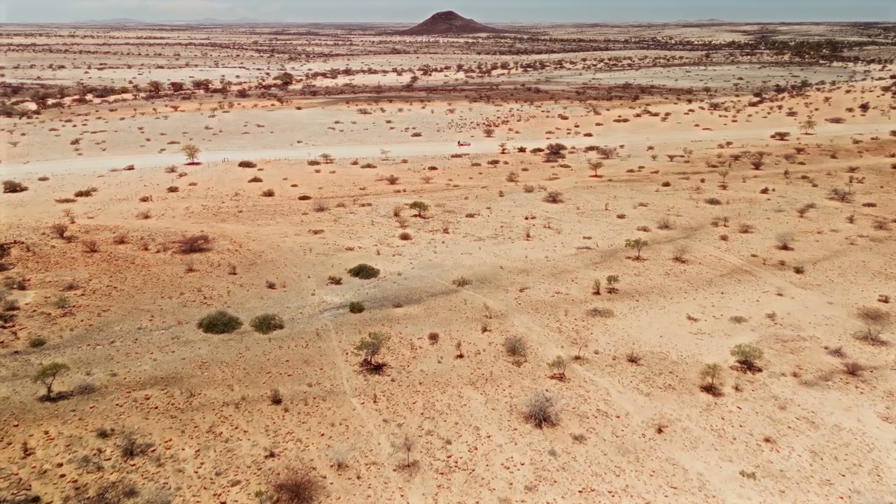 Vehicle Driving Through Vast Desert Landscape