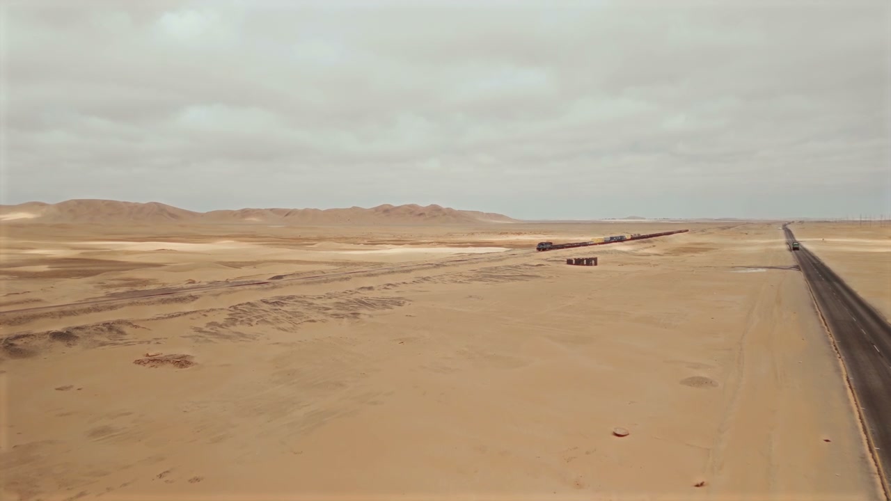 Freight Train and Road in Desert Landscape