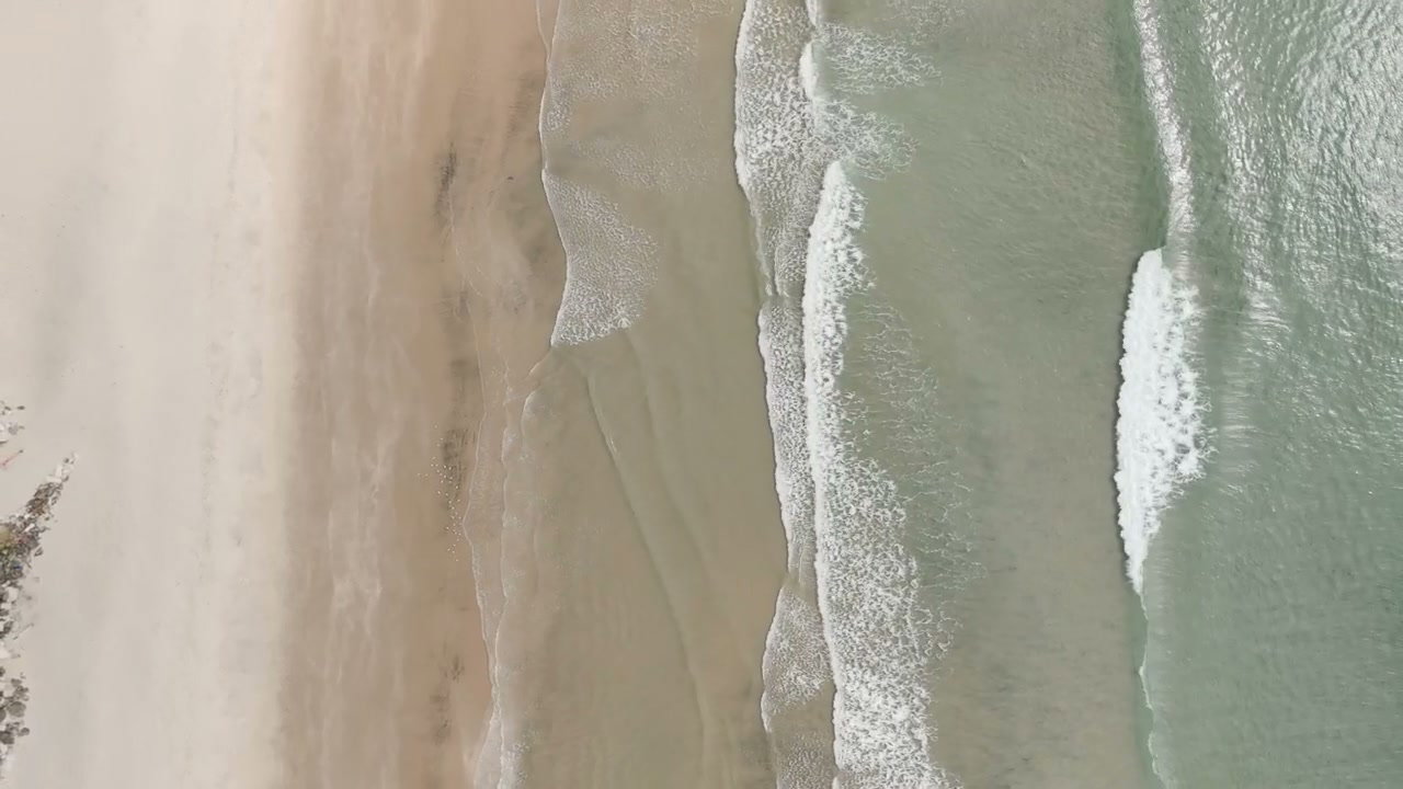 Aerial View of Waves Breaking on New Zealand Beach