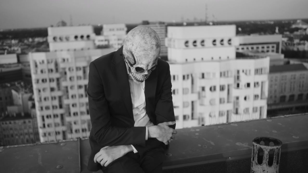 Person in Skull Mask on City Rooftop