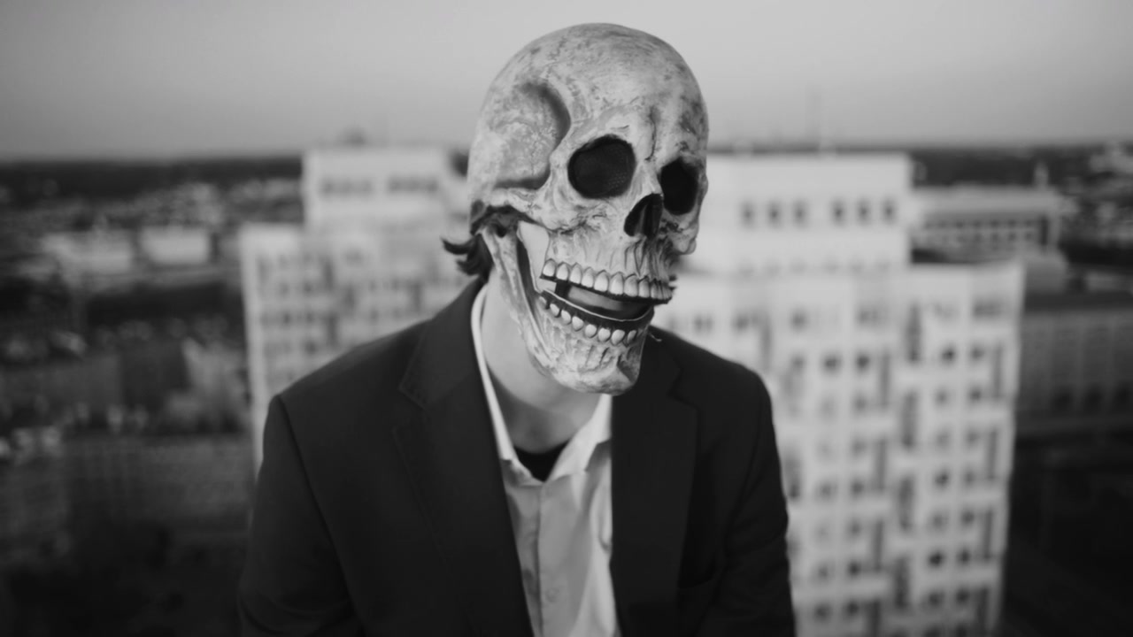 Distressed Figure in Skull Mask on Rooftop