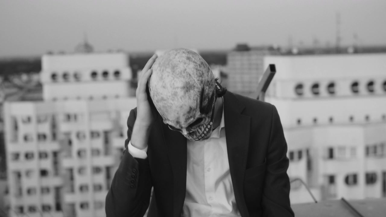 Person in Skull Mask Showing Distress on Rooftop