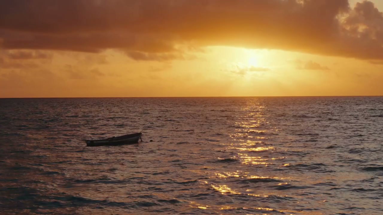 Golden Sunset Over Ocean with Small Boat