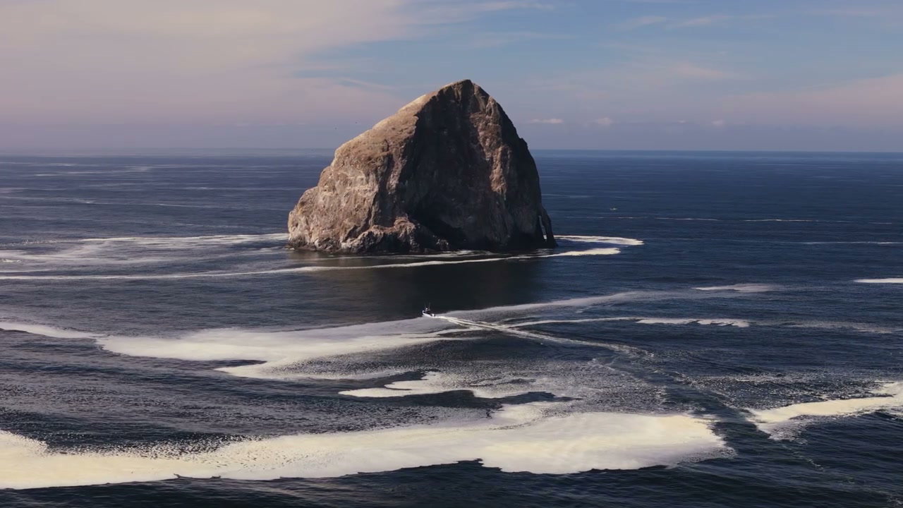 Boat Sailing by Pacific Coast Sea Stack