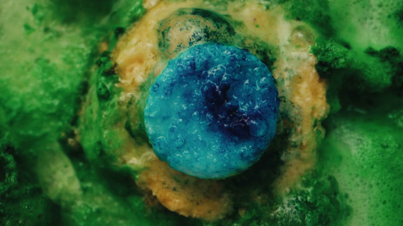 Colorful Blue Pill Reacting in Green Liquid