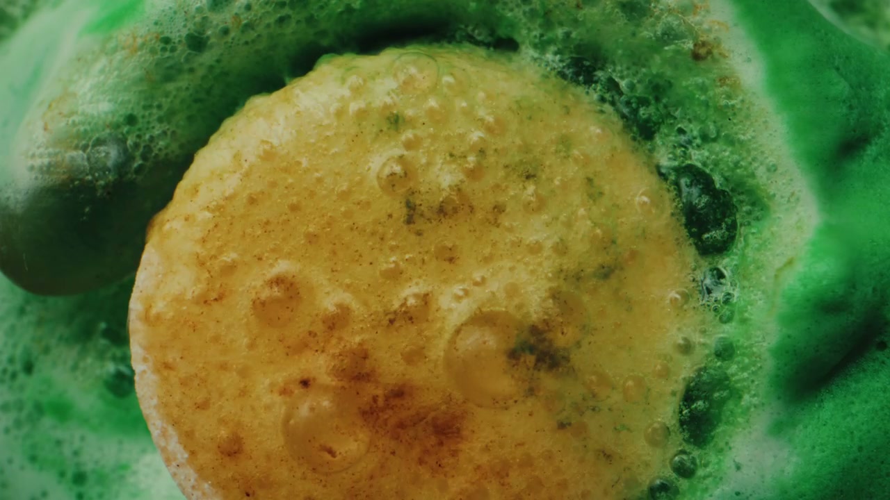 Yellow Tablet Fizzing in Green Liquid