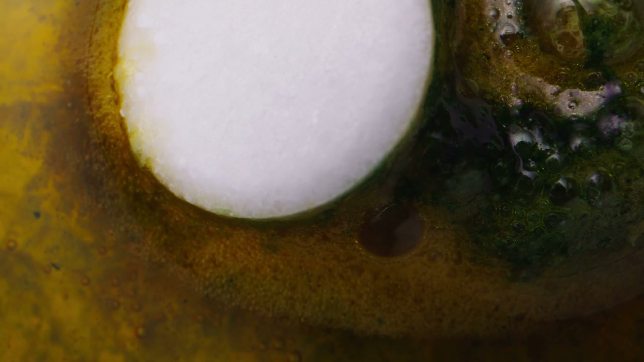 Bubbling Colorful Liquids Around a Tablet