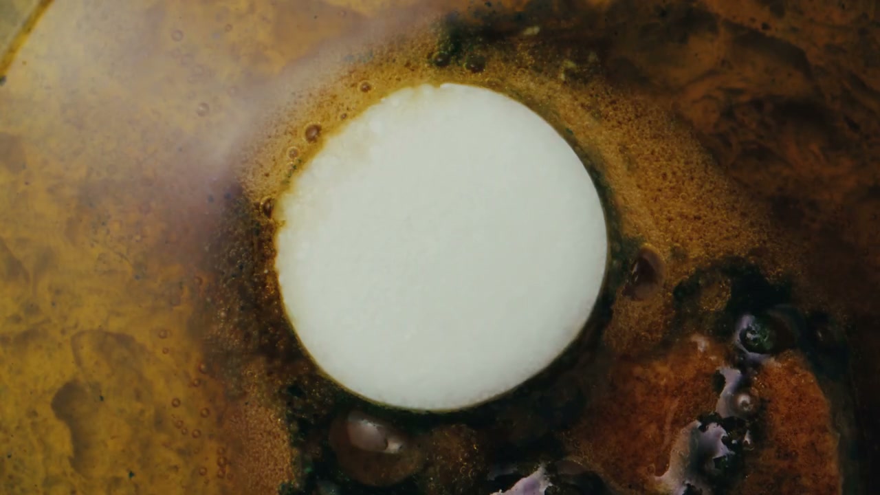 White Tablet Dissolving in Abstract Liquid