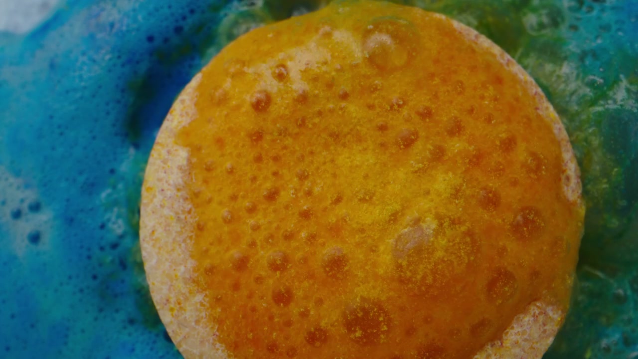 Orange Bath Bomb Fizzing in Blue Water