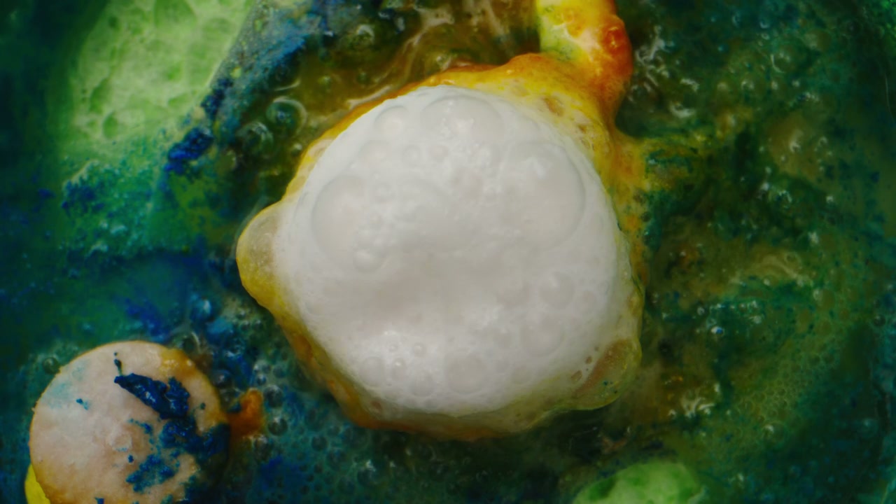 White Foam Bubbling in Colorful Green Liquid