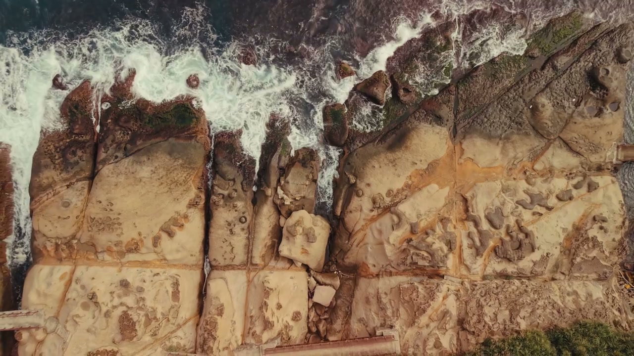 Aerial View Of Ocean Waves On Rocky Shore