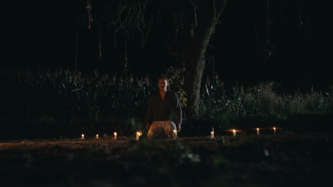 Person Performing Night Ritual with Candles