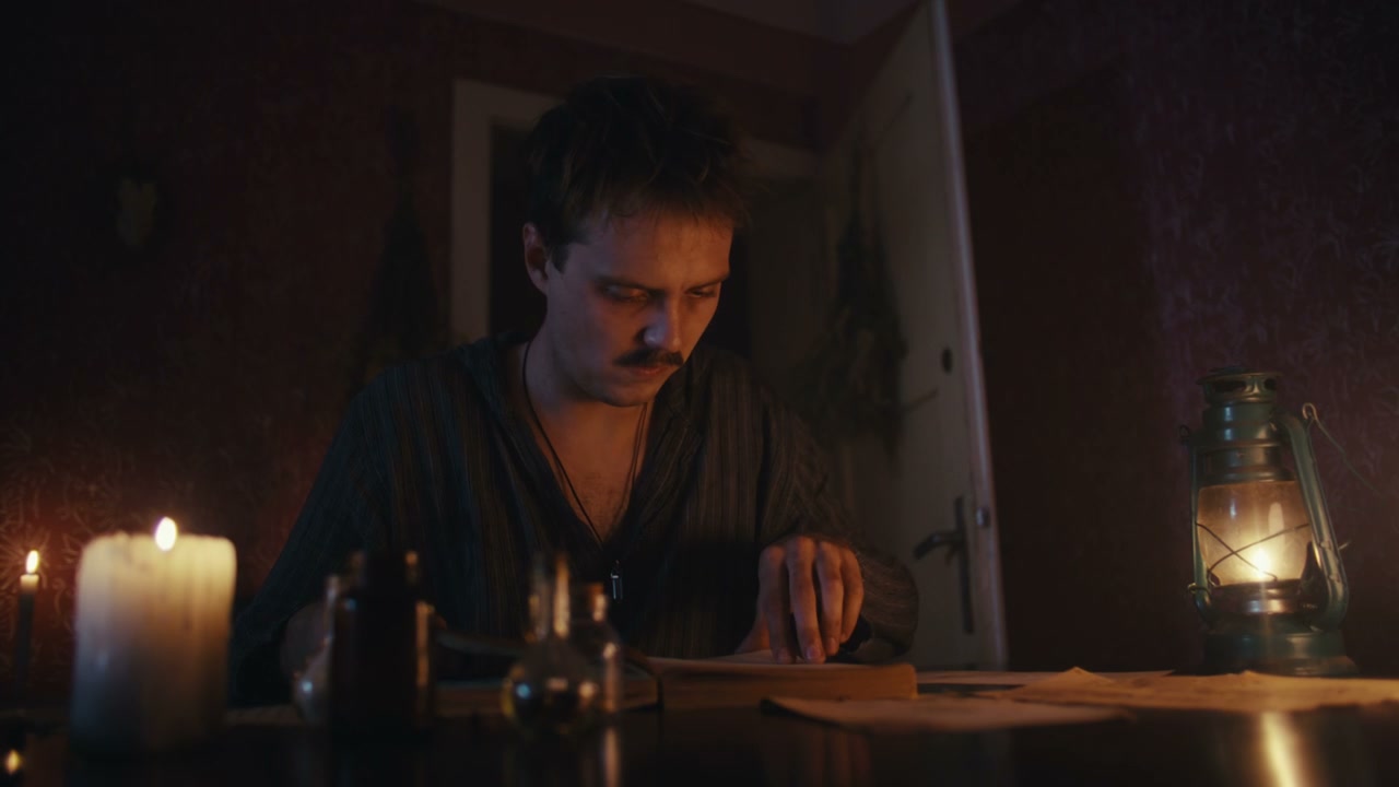 Man Studying Old Book and Vials by Candlelight