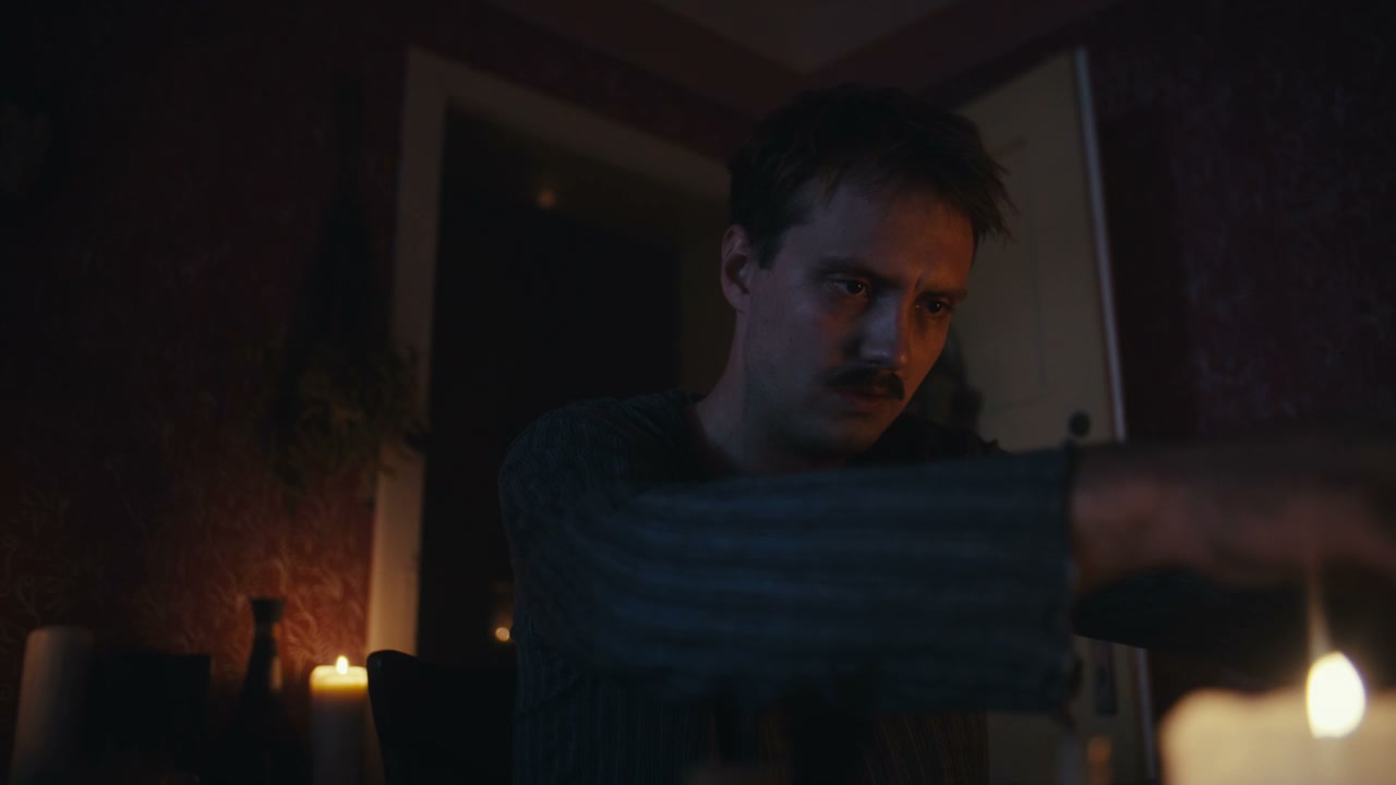 Man Examining Objects by Candlelight