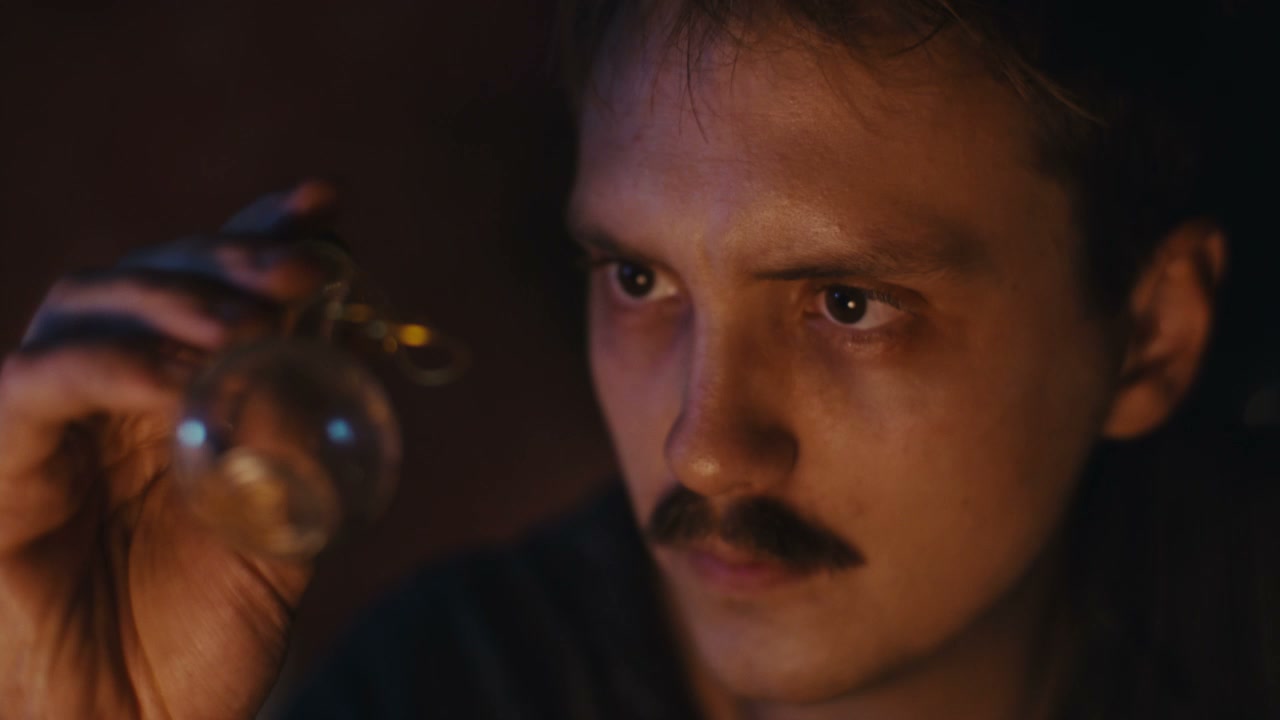 Man Inspecting Old Ritual Vial
