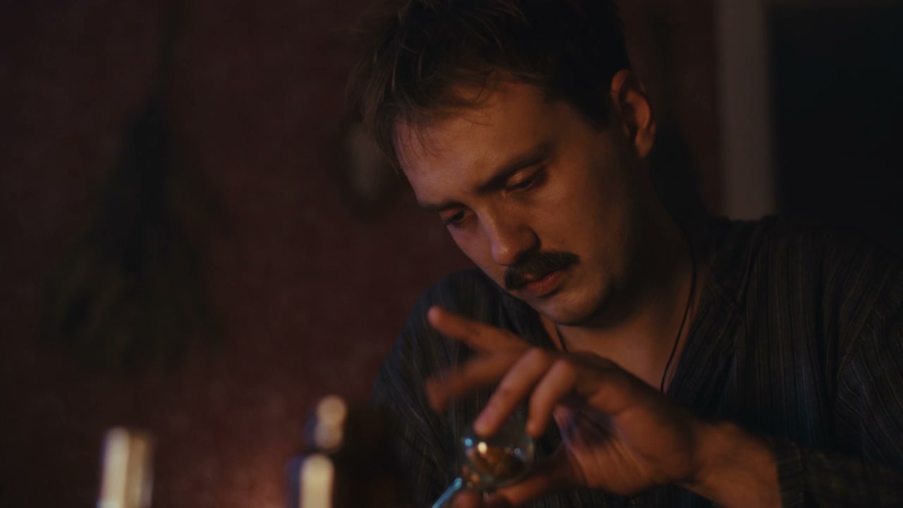 Man Examining Ritual Object in Dim Light