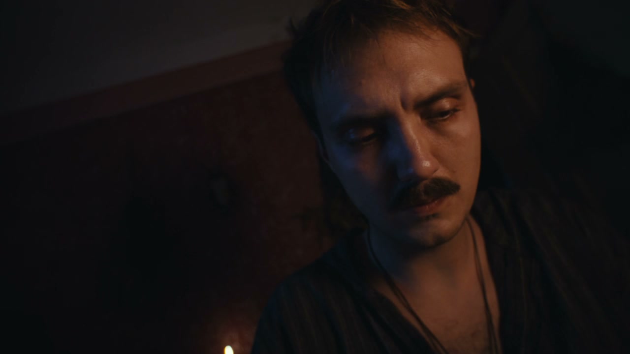 Man Shaking Ritual Herbs in Dark Room