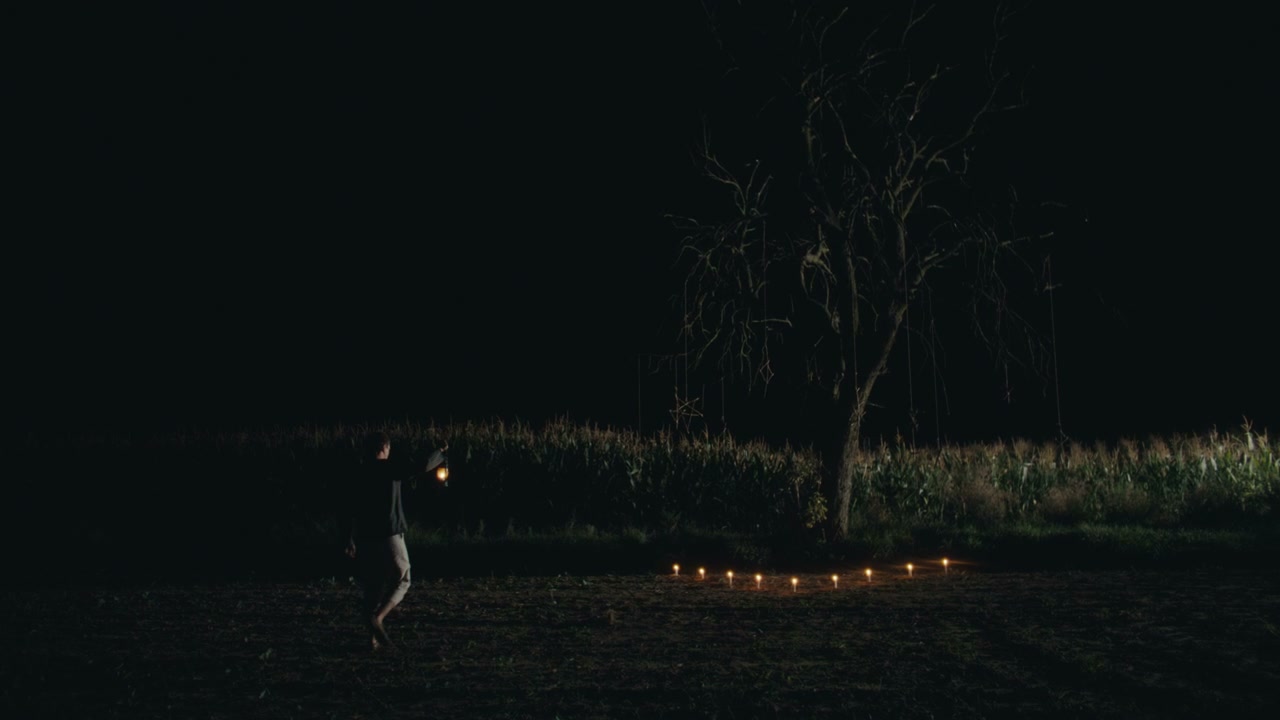 Figure with Lantern Approaches Candles at Night