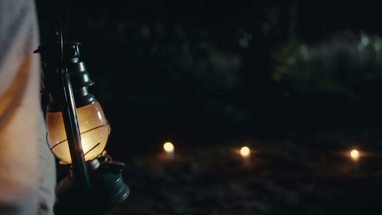 Person Carrying Lantern at Night