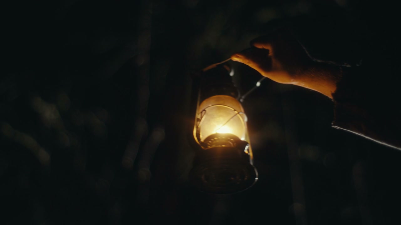 Hand Holding Lantern in Dark Night