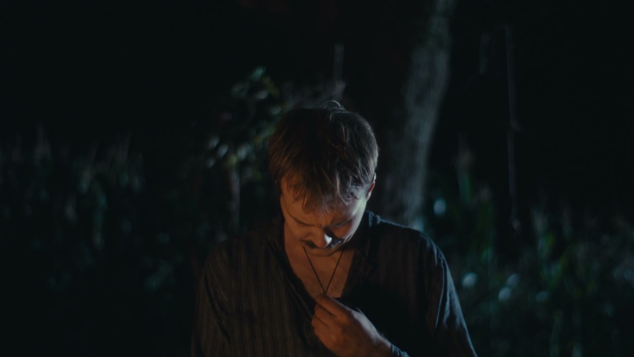 Man Meditating with Amulet by Fire at Night