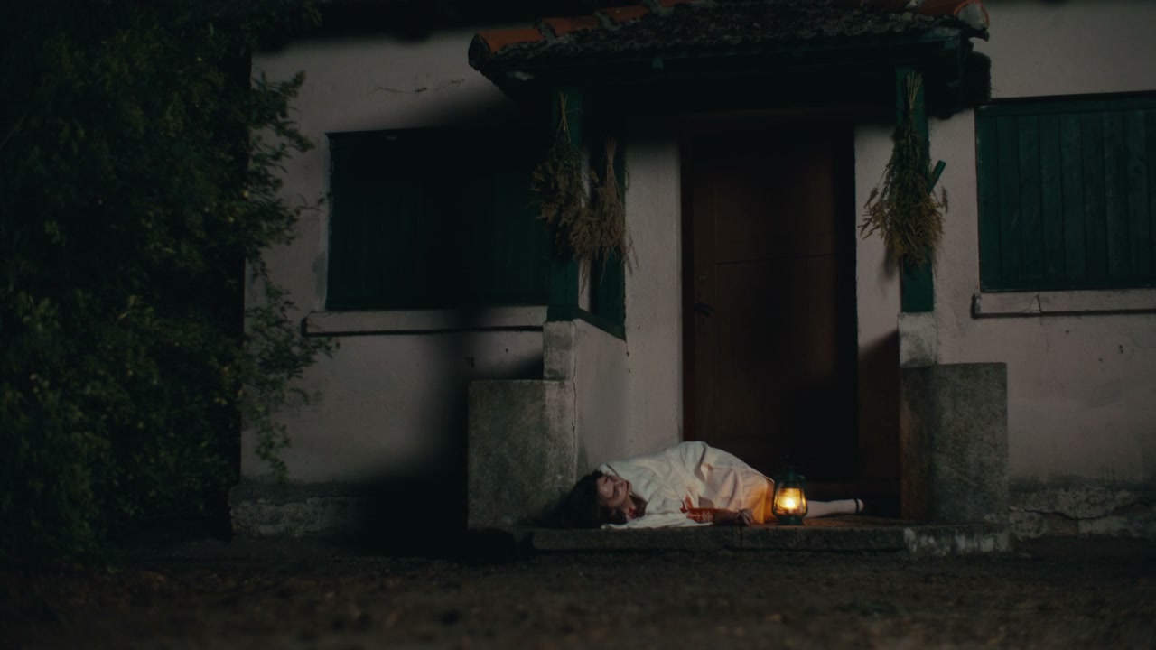 Person Lying on Porch of Rustic House at Night