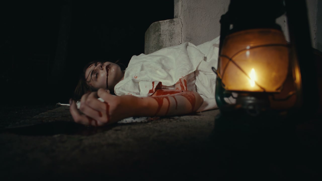 Bloody Person on Ground by Lantern at Night