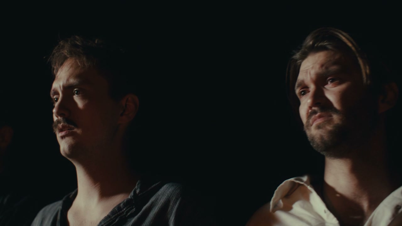Two Men with Serious Expressions in Darkness