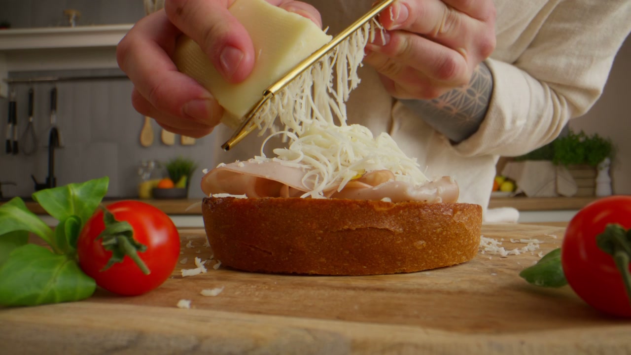 Close-Up Grating Cheese on Hot Dog Bun