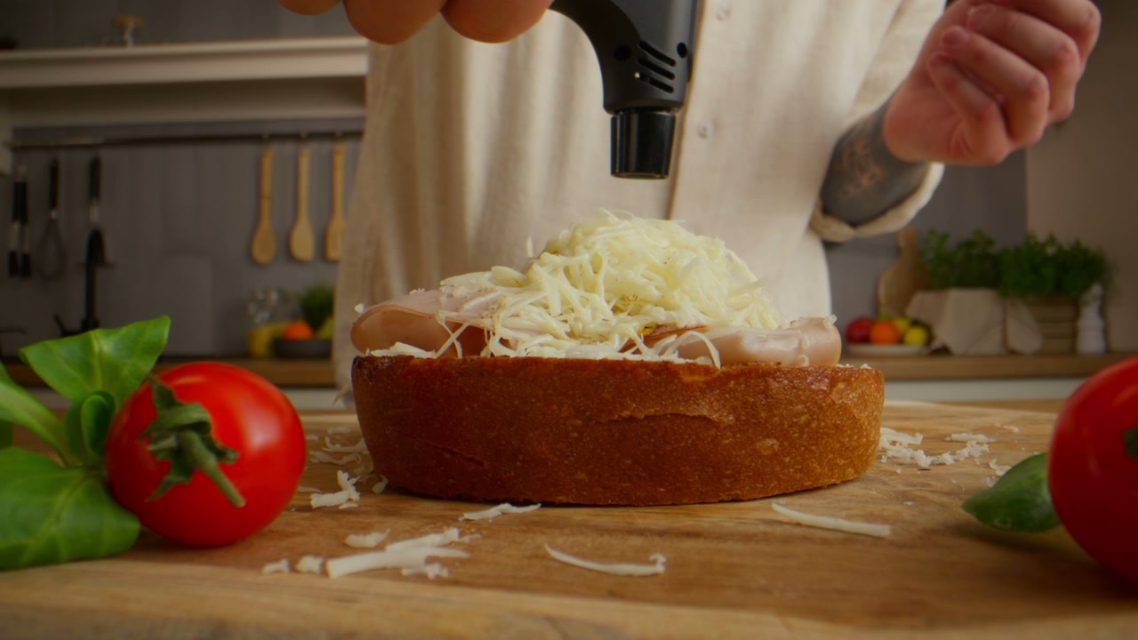 Chef Melting Cheese on Hot Dog Sandwich