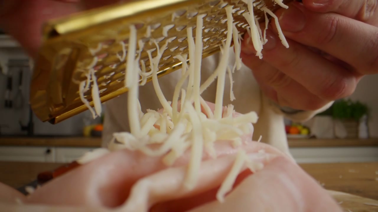 Close Up of Cheese Grating Over Ham