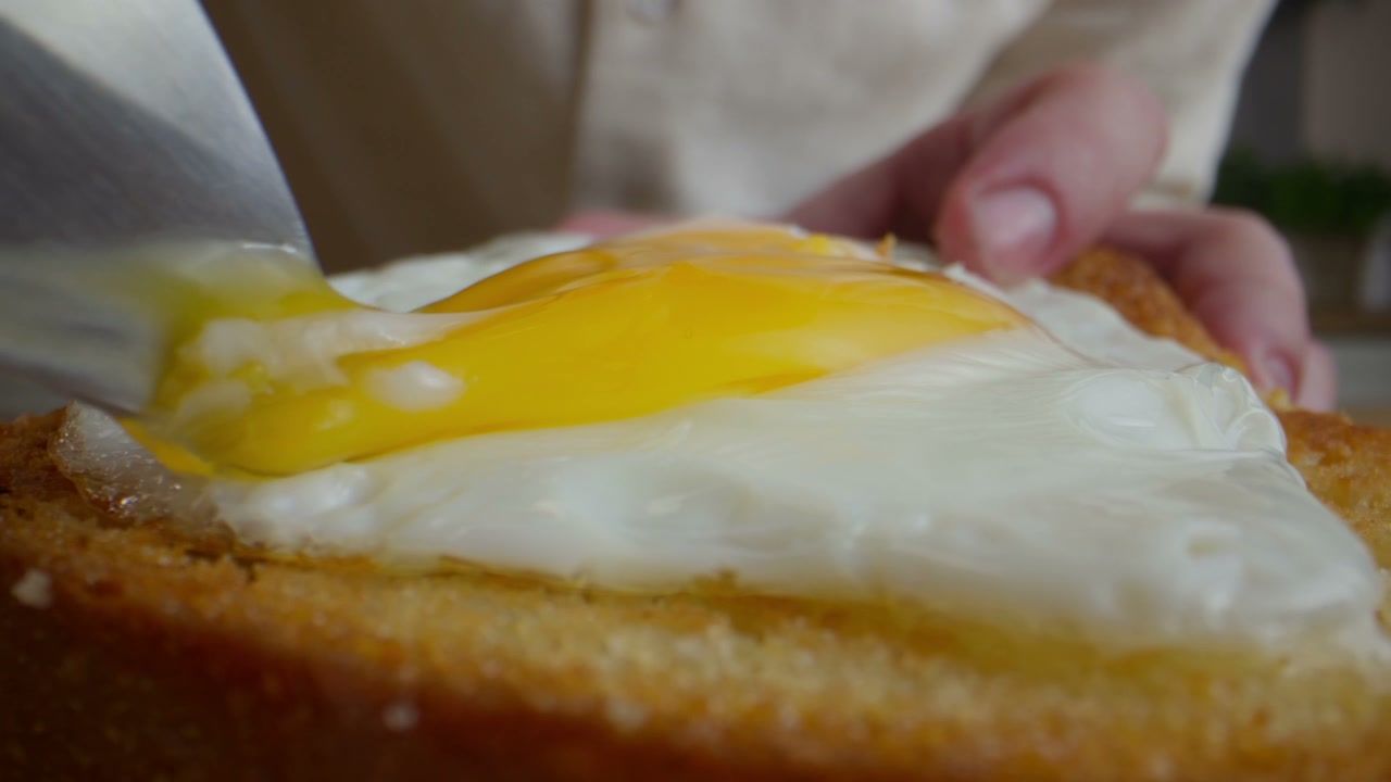 Cutting Runny Fried Egg on Toast
