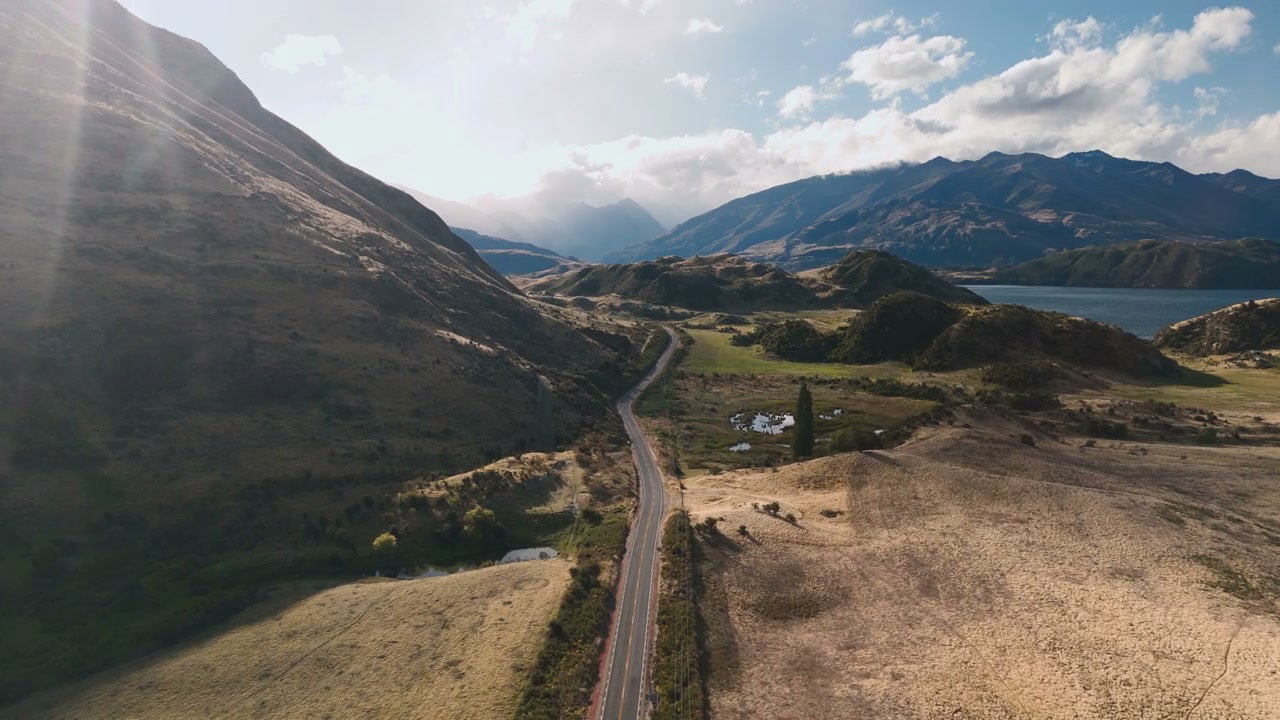 Winding Road Through Sunny Mountain Valley