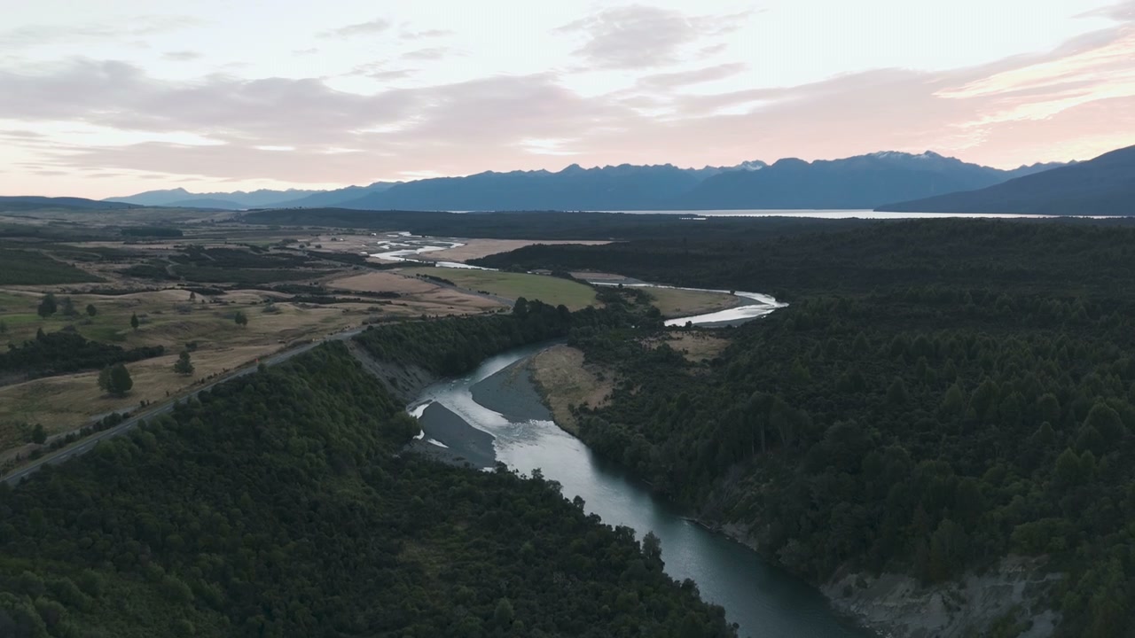 River Through Forested Valley at Sunset
