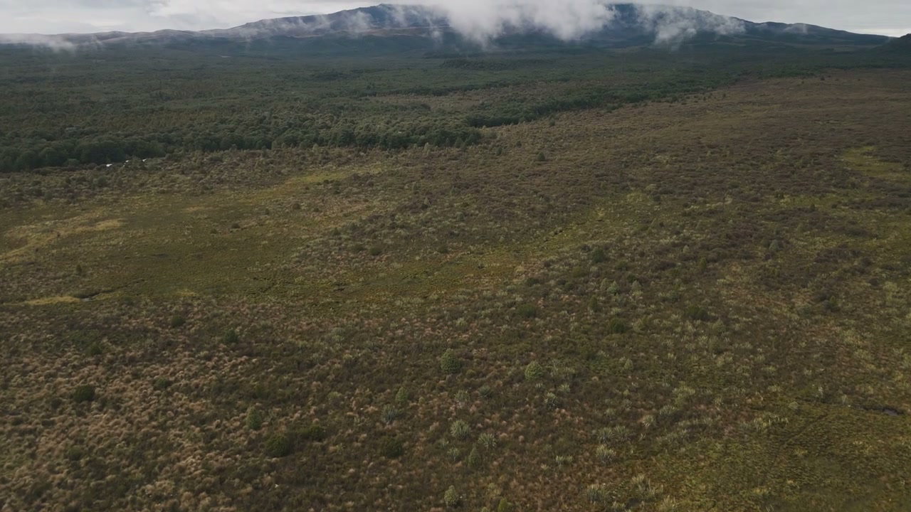 Aerial Over Green Moorland and Cloudy Mountains
