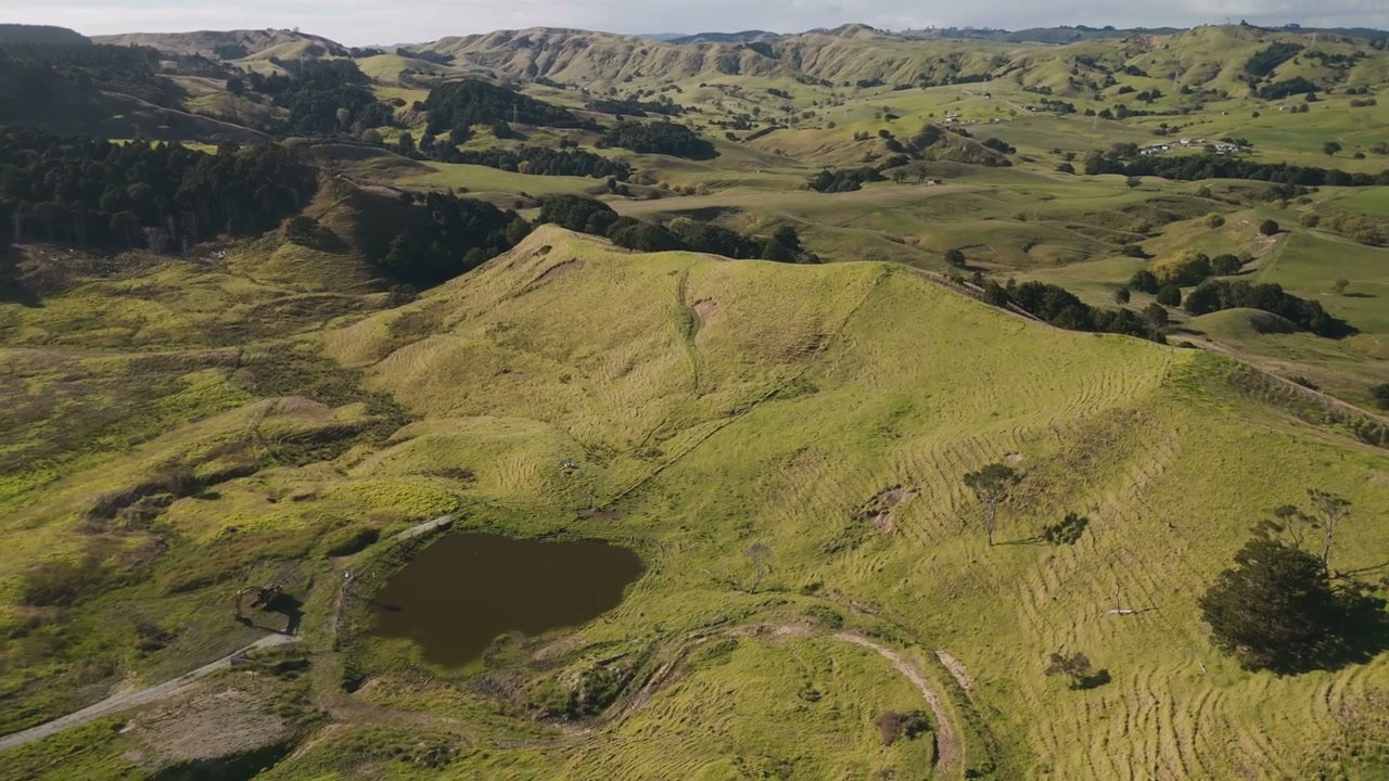 Aerial View of Rolling Green Hills and Pond