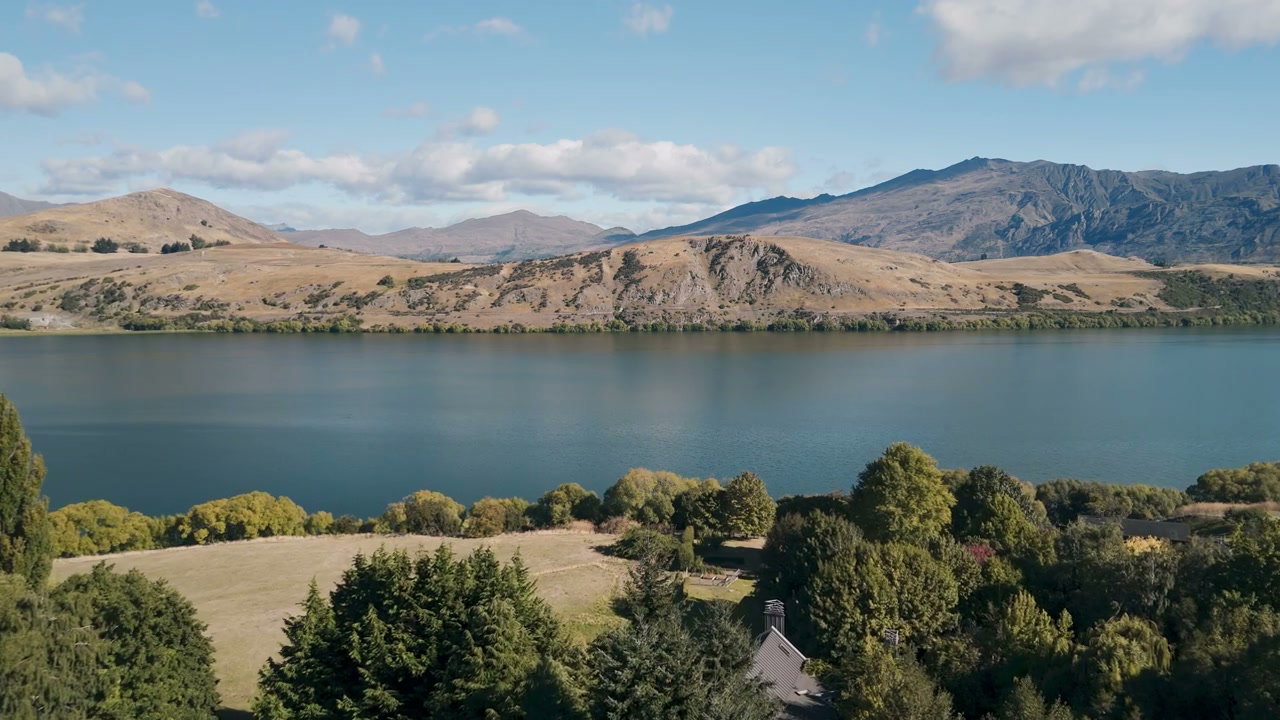 Lake Surrounded by Mountains and Green Fields
