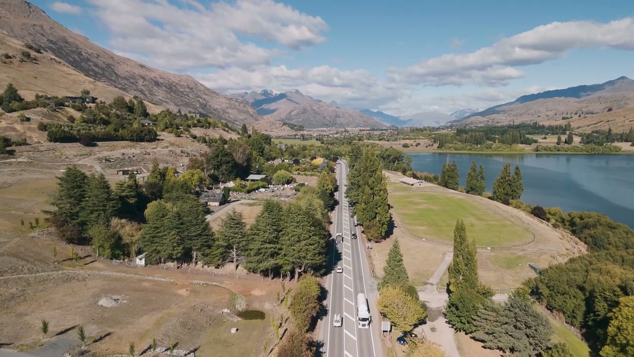 Aerial View of Scenic Road by Lake and Mountains