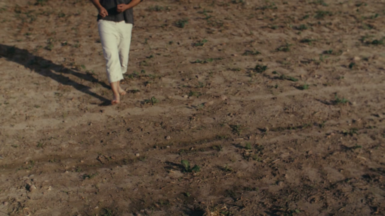Melancholy Man Standing in Dry Field