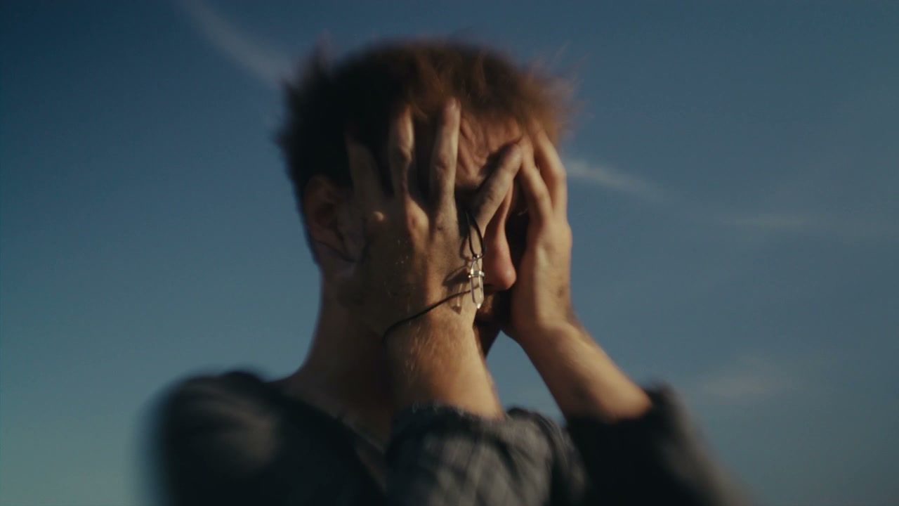 Man Crying in Distress Under Blue Sky