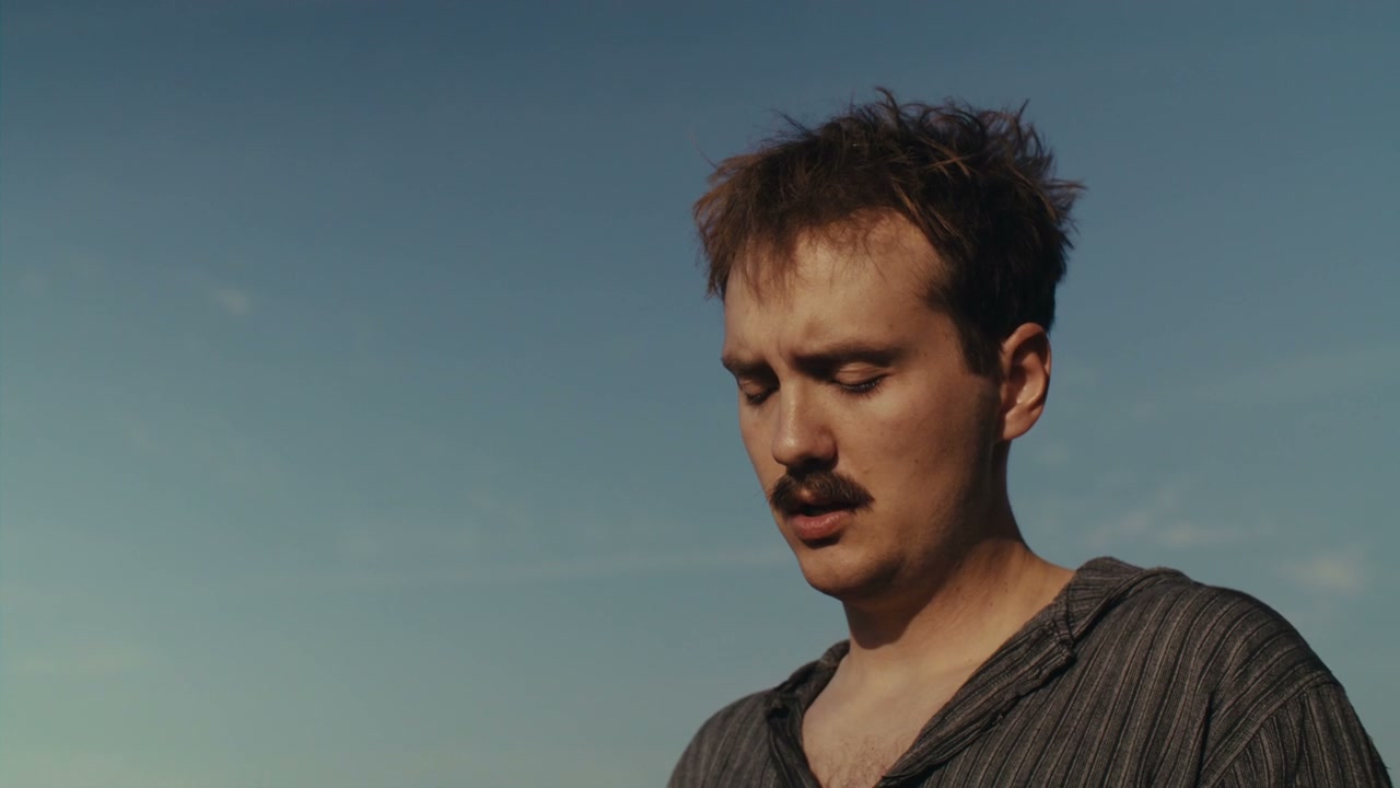Man Looking Thoughtful Under Blue Sky