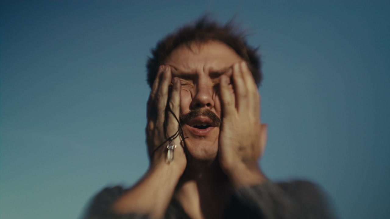 Distressed Man Covering Face Against Blue Sky