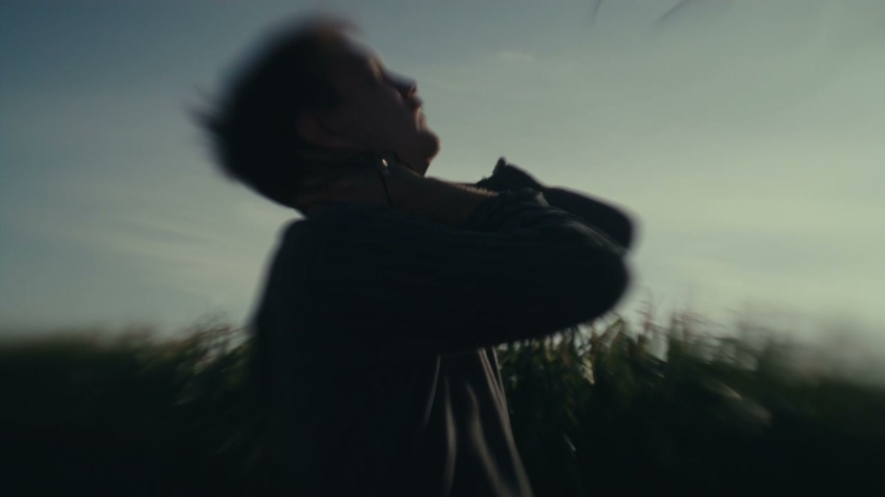 Distraught Young Man Holding Head in Field